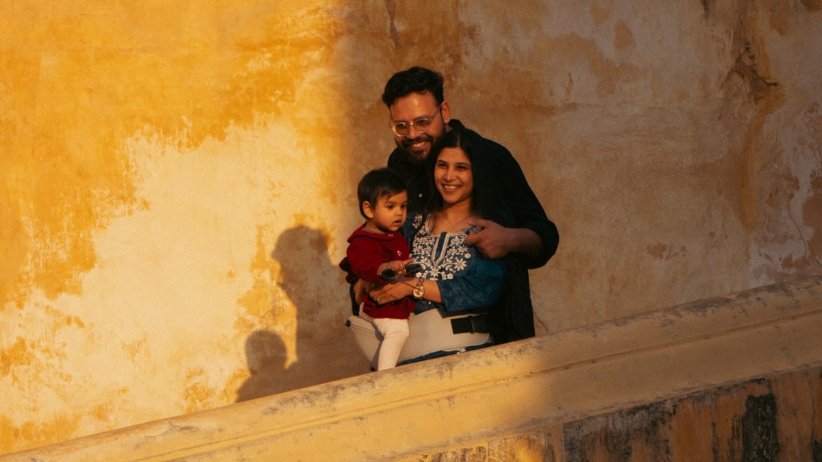 A family posing against a textured yellow wall.